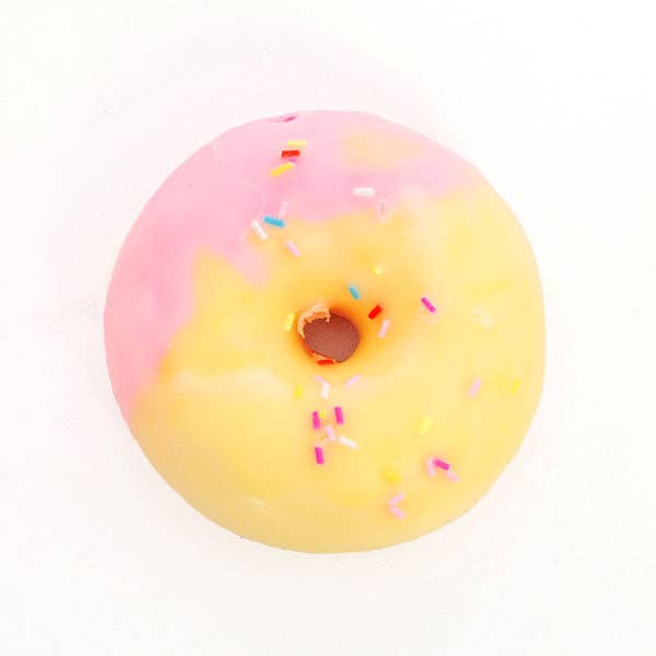 A novelty donut-shaped object with a pink and yellow gradient glaze and colorful sprinkles, photographed from above on a plain white background.