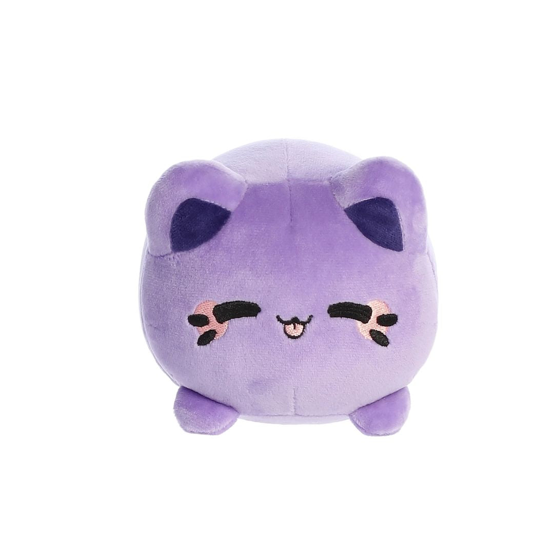 Front view of a small purple plush toy shaped like a round cat, with darker purple inner ears, embroidered closed eyes, whisker markings with pink accents, a small stitched smiling mouth, and short stubby legs, shown on a white background.