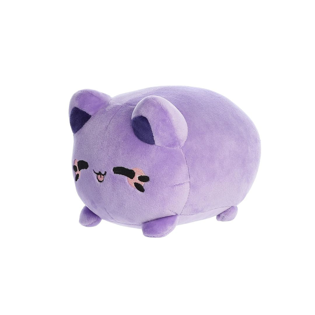 Angled front view of a small purple plush toy shaped like a rounded cat, with darker purple inner ears, embroidered closed eyes, whisker markings, a small stitched smiling mouth, and short stubby legs, shown on a white background.