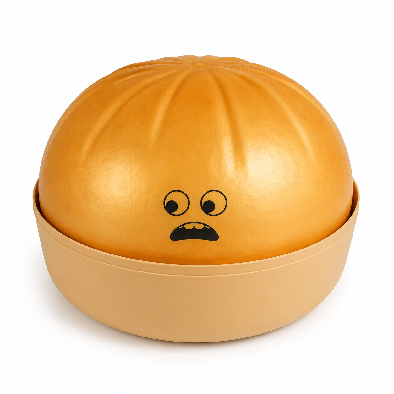 Golden squishy dumpling toy, with a raised lid featuring a simple black cartoon face. The base is a matching light tan bowl, all photographed on a clean white background.