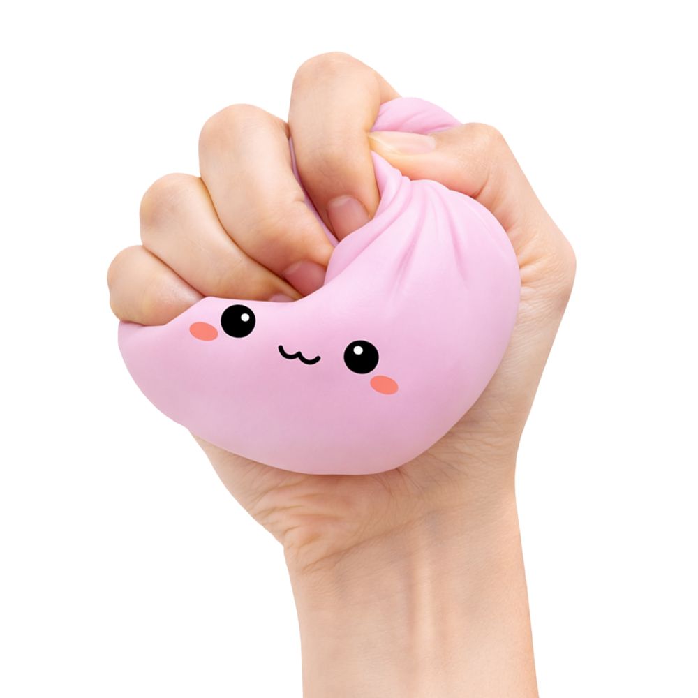 Hand holding a pink squishy dumpling toy with a face design on a white background