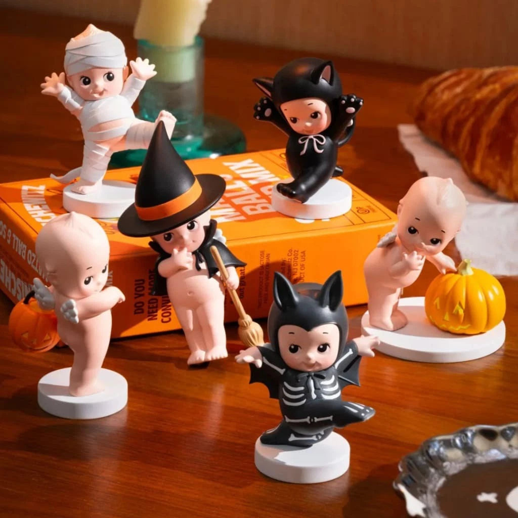 Set of Smoko Kewpie Halloween-themed figurines on a wooden surface with a box in the background