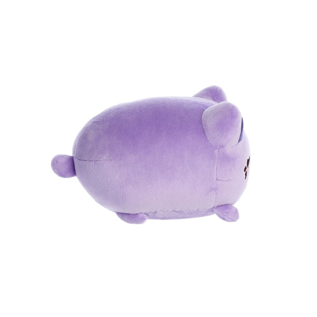  Side view of a small purple plush toy shaped like a rounded cat, with short legs, a tiny tail, darker purple inner ears, and embroidered facial details partially visible, shown on a white background.