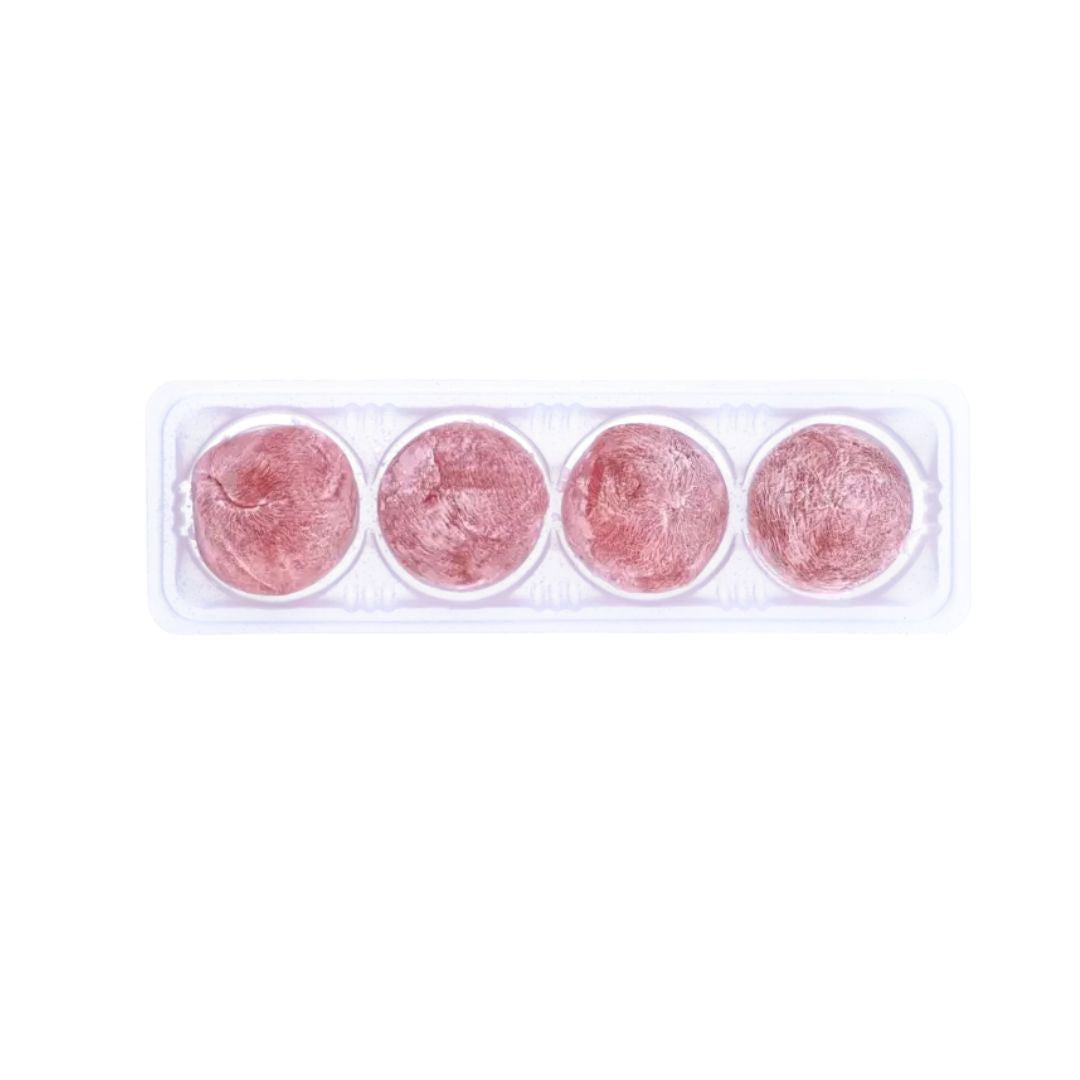 plastic tray containing four Mochi arranged in a single row, each round and pinkish-red with a slightly uneven texture, on a clean white background.