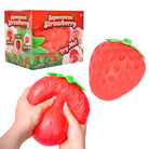 Red strawberry-shaped squishy toy with packaging on a white background
