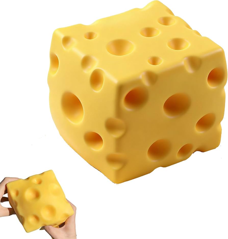 A yellow cheese-shaped stress toy with large holes, shown on a white background with a smaller inset of hands squeezing it.