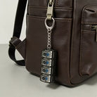 keyboard clicker keychain attached to brown bag