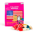 Bright pink IT’SUGAR “IT’S American” candy mix bag featuring an American flag graphic, placed on a white background with assorted red, white, and blue gummy candies in front.