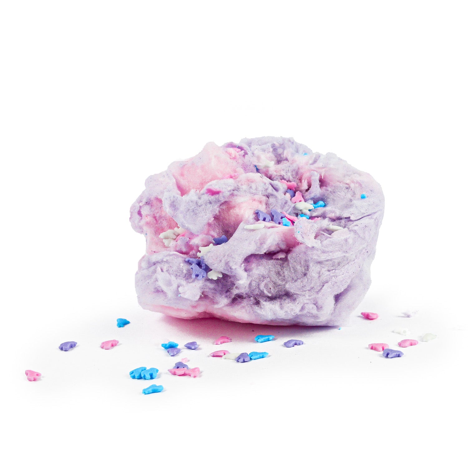 A fluffy piece of pink and purple cotton candy with small colorful candy sprinkles scattered around it on a white background.