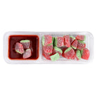 A clear plastic two-compartment candy tray on a white background. The left compartment contains four dark red, sugar-dusted candy pieces partially submerged in a chamoy dipping sauce.