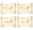 Four RingPop baby candy packages arranged in a 2x2 grid on a white background. The packages are cream-colored with gold lettering and a pink pacifier graphic, featuring slogans 'HARD LAUNCH', 'LOVE IS SWEET', 'I'M YOURS', and 'SAY YES'.