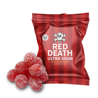 A red and dark red striped bag of Red Death Ultra Sour candies with a pile of red sugar-coated candies in front, on a solid white background.