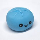 A light blue, round, dumpling-shaped edible candy with a cute black embroidered face, shown on a plain white background.