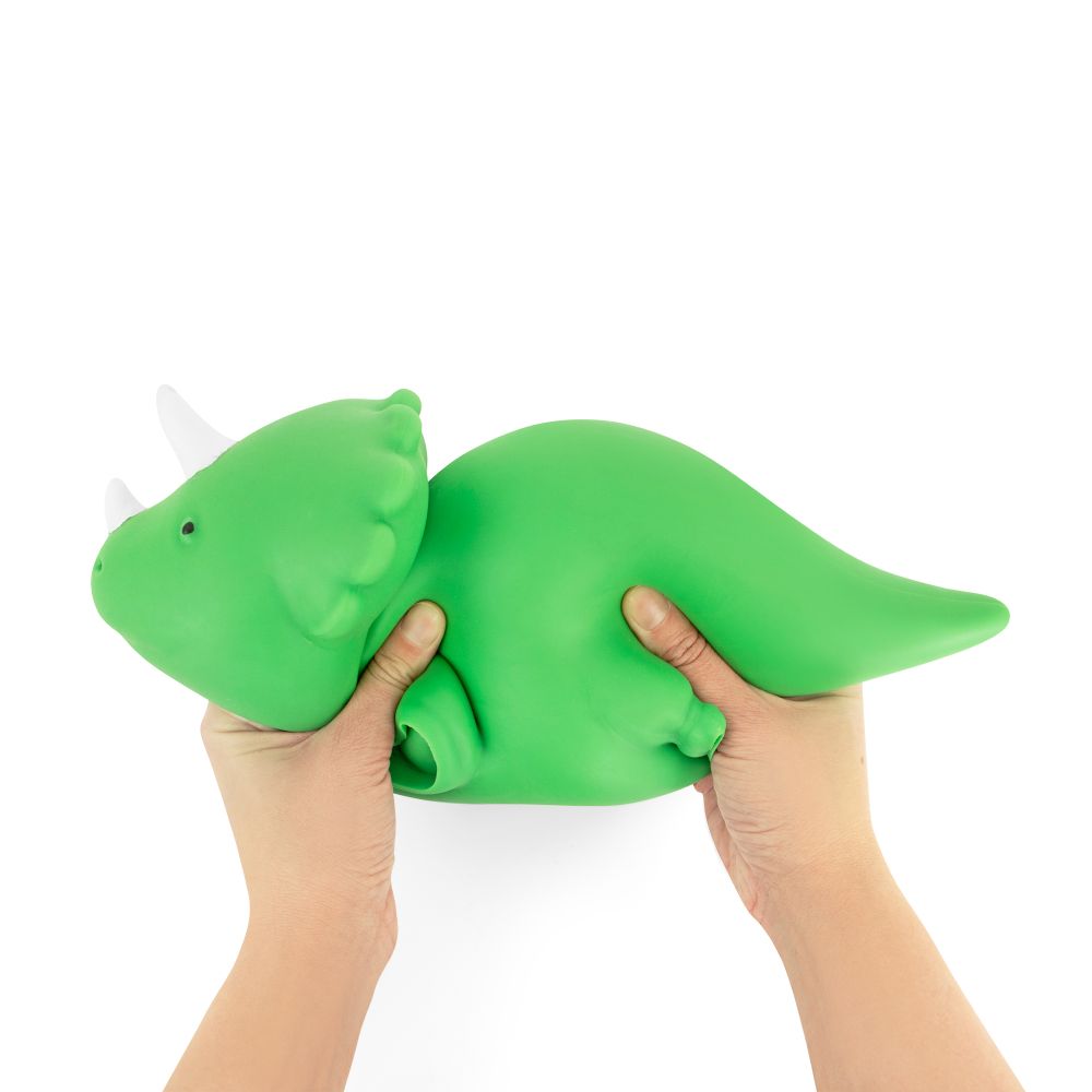 Green dinosaur-shaped stress ball held by two hands on a white background