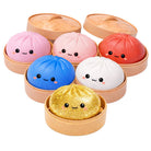 Set of colorful dumpling squishies with faces in a steamer-like container on a white background