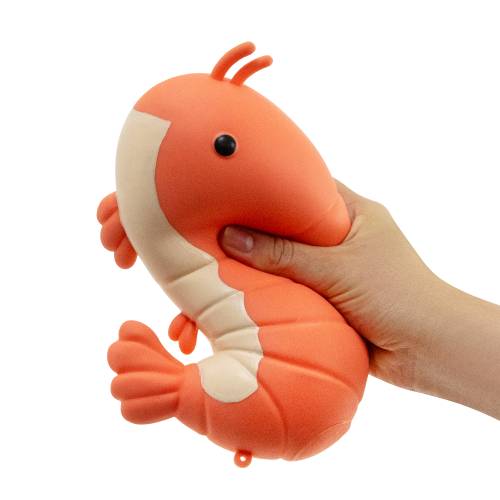 Hand holding a plush shrimp toy against a white background